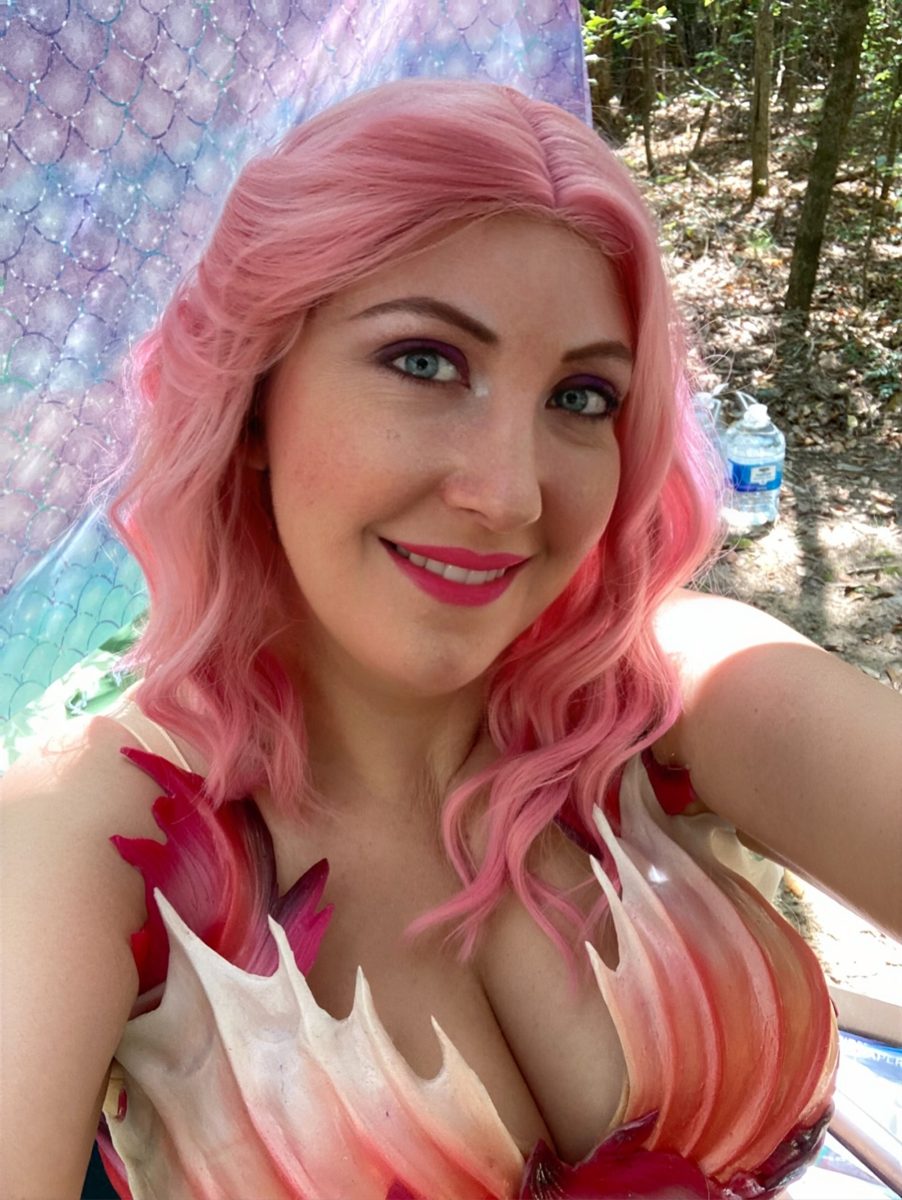 Mermaid with pink wavy hair and a coral shell top