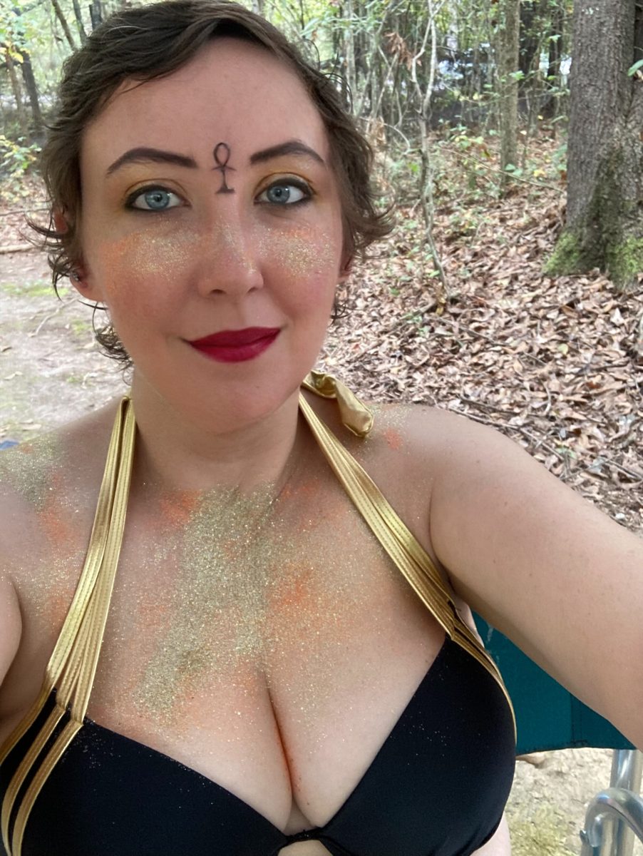 Mermaid with gold scale face paint in the forest